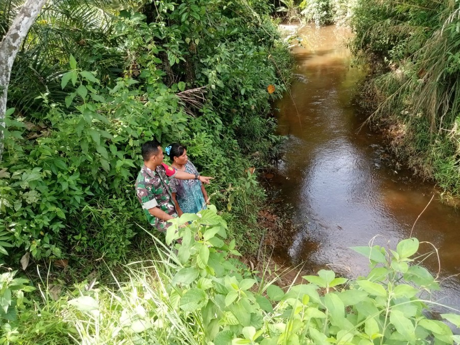 Selalu waspada dengan bencana alam Serka harmizan turun ke lapangan guna pastikan aliran sungai masih dalam keadaan aman.