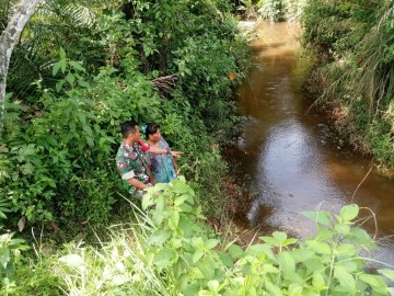 Selalu waspada dengan bencana alam Serka harmizan turun ke lapangan guna pastikan aliran sungai masih dalam keadaan aman.