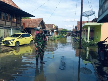 Wujud Perhatian Babinsa Sertu Antoni Pantau Lokasi Banjir di Wilayah Binaannya