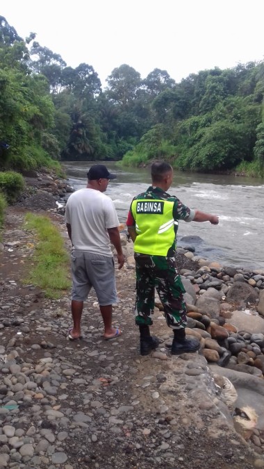 Babinsa Koramil 406-08/Lubuklinggau Serda gunawan melaksanakan pemantauan aliran sungai yang sering meluap didesa binaan.