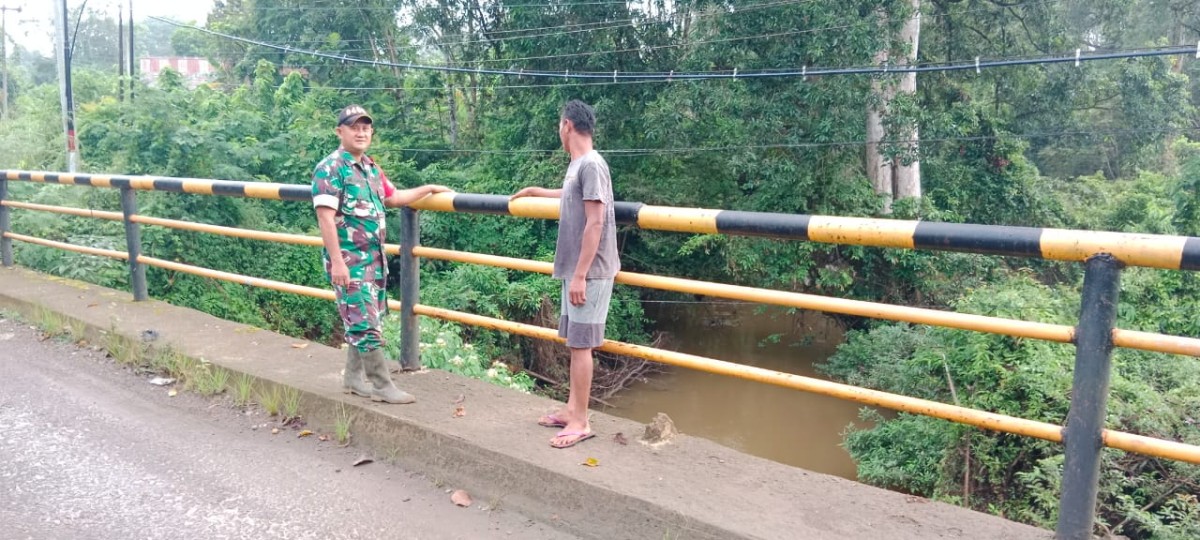 Curah hujan tinggi Sertu M Daud Babinsa Koramil 406-07/jayaloka cek Debit air di wilayah desa binaan.
