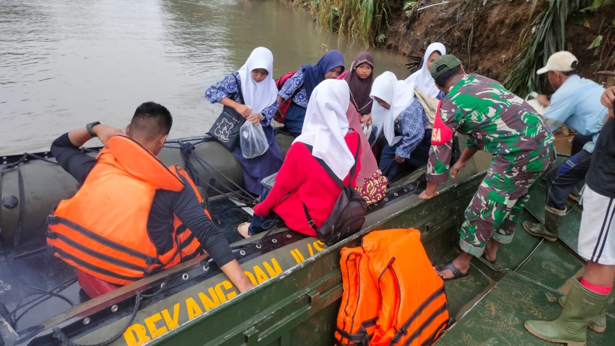 Serda fauzi koramil 046-03/muara rupit desa suka menang membantu penyebrangan anak sekolah dan masyarakat dalam beraktifitas