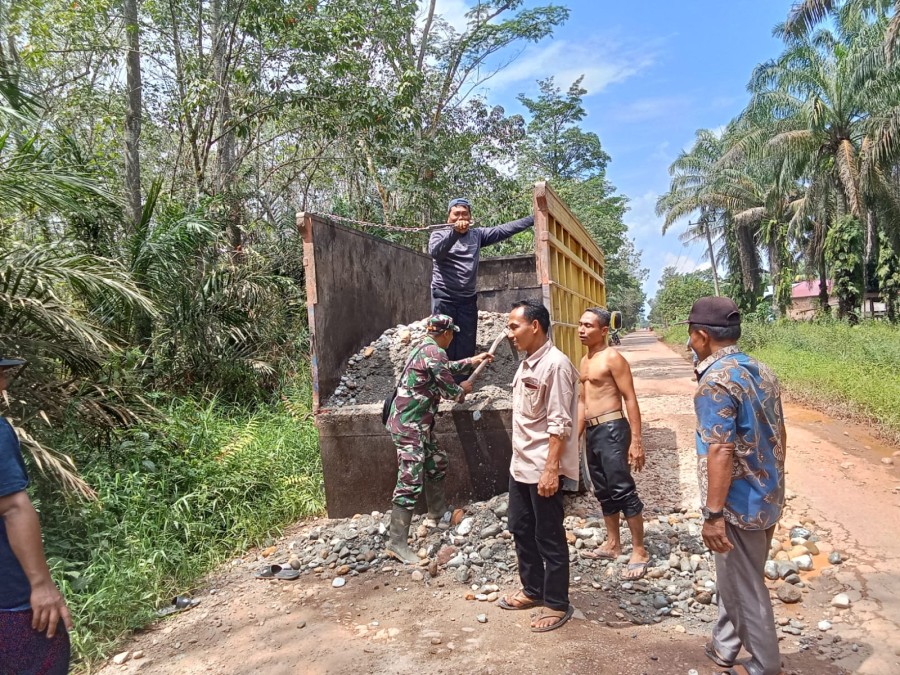 Serda Suripto Babinsa Koramil 406-04/Muara Lakitan Bersama Warga Gotong-royong Timbun Jalan Berlubang