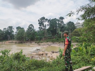 Babinsa melaksanakan monitoring kegiatan Gulbencal pengecekan debit air sungai rawas.