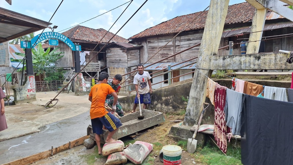 Serda Febri Yanto, Babinsa Koramil 406-03/Rupit, Bersama Warga Desa Embacang Lama Gotong Royong Pengecoran Jalan