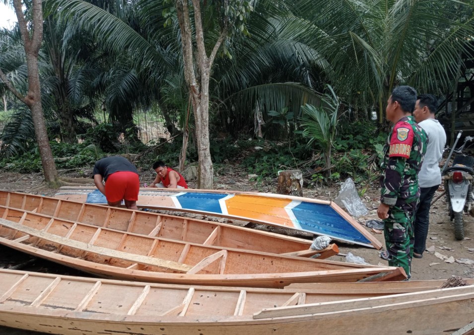 Babinsa Koramil 406-03/Rupit, Serda Ade Kurnia, Tinjau Pembuatan Perahu di Desa Muara Batang Empu