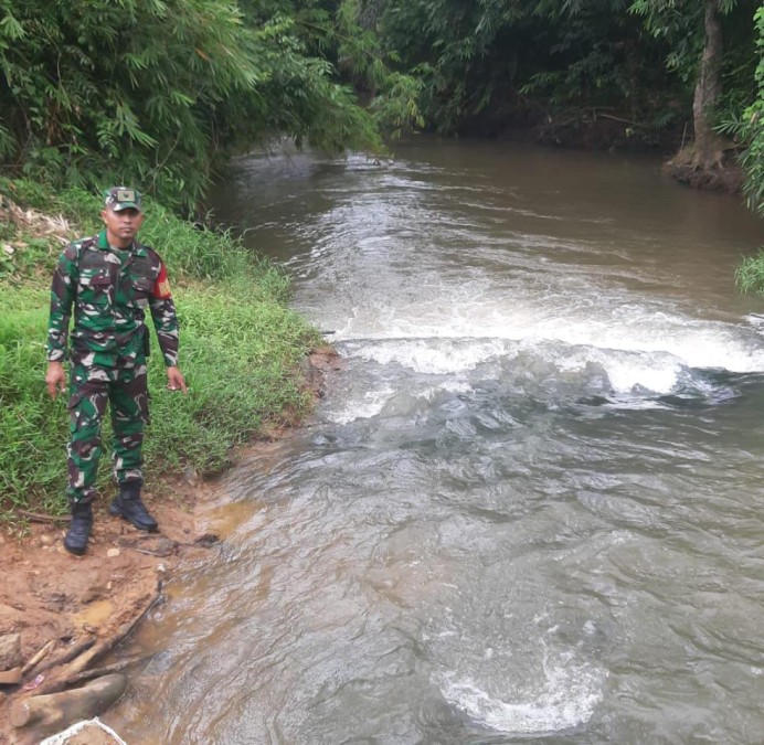 Babinsa Koramil 406-06/Tugumulyo Lakukan Pengecekan Aliran Sungai di Wilayah Rawan Banjir