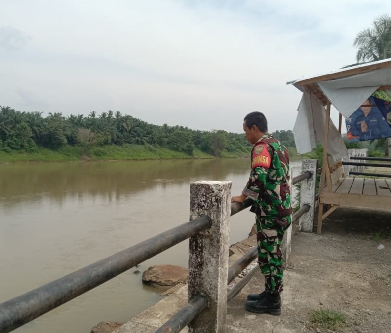 Babinsa Koramil 406-04/Muara Lakitan Aktif Lakukan Pemantauan Arus Sungai Lakitan untuk Antisipasi Banjir
