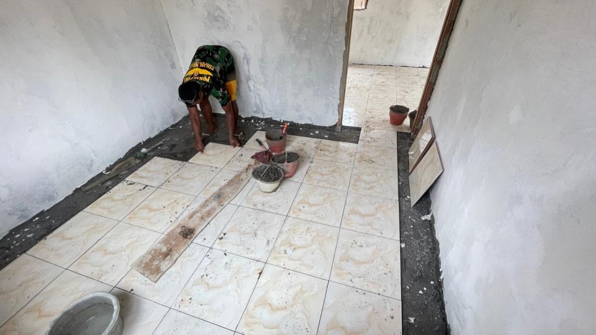 Sertu Purwanto Pimpin Langsung Tahap Plamir dan Pemasangan Keramik Pembangunan Rumah Layak Huni TMMD ke-125 Kodim 0406/Lubuklinggau