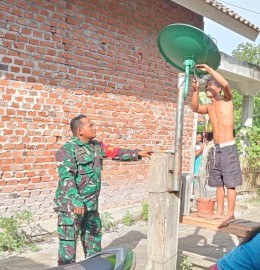 Babinsa Koramil 406-04/Muara Lakitan Bantu Warga Perbaiki Parabola di Desa Sungai Dangku
