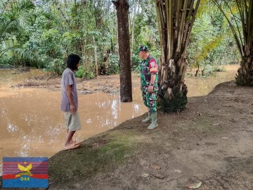 Babinsa Koramil 406-07/Jayaloka Aktif Cek Debit Air Sungai, Antisipasi Banjir di Wilayah Binaan